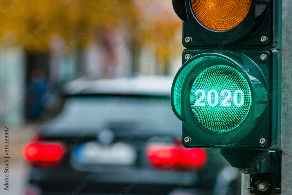 A city crossing with a semaphore. Green light with text 2020 in semaphore. New Year concept. - obrazy, fototapety, plakaty 