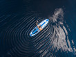Man rowing oar on sup board blue sea water. Aerial top view paddleboard