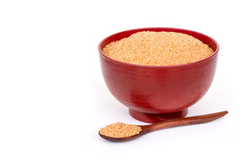 Wall Mural - Brown sugar in red bowl  isolated on white background.