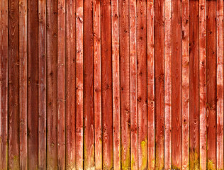 Colored wooden background from boards. Wooden boards from an old fence. Red beautiful wood texture. New Year and Christmas background.