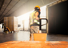 Workers Using Hand Pallet Jack Unloading Package Boxes Into Cargo Container. Delivery Shipment Boxes. Trucks Loading At Dock Warehouse. Supply Chain. Warehouse Shipping Transport And Logistics.