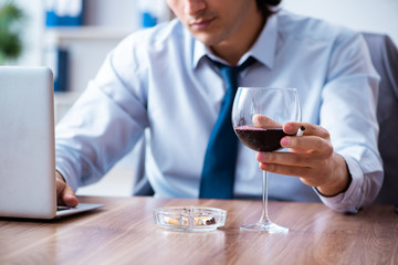 Poster - Male employee drinking alcohol and smoking cigarettes at workpla