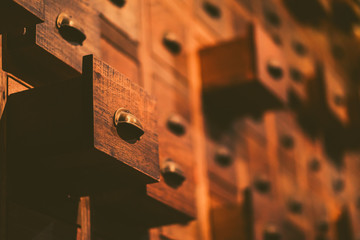 Old wooden textured drawers background in chinese herbal medicine shop in china.Vintage asian objects.