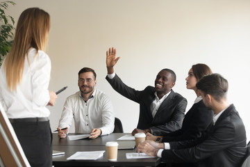 Poster - Motivated biracial male employee raise hand answering at team training