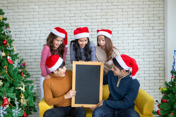 Sticker - A group of Asian friends held blank signs at a Christmas celebration and enjoyed a happy New Year at home.