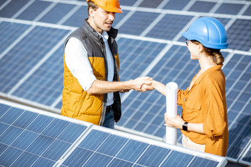 Wall Mural - two successful engineers or architects having a deal, shaking hands while standing between rows of s