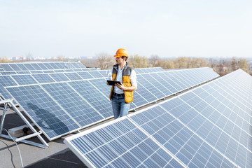 Wall Mural - view on the rooftop solar power plant with mann walking and examining photovoltaic panels. concept o