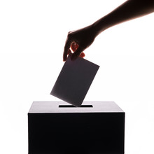 Silhouette Of Voter Putting Ballot Into Voting Box. Isolated Background With Copy-space