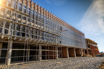 Extensive scaffolding providing platforms for work in progress on a new apartment block,Tall building under construction with scaffolds,Construction Site of New Building