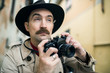 © Minerva Studio - Man using vintage camera in a city street