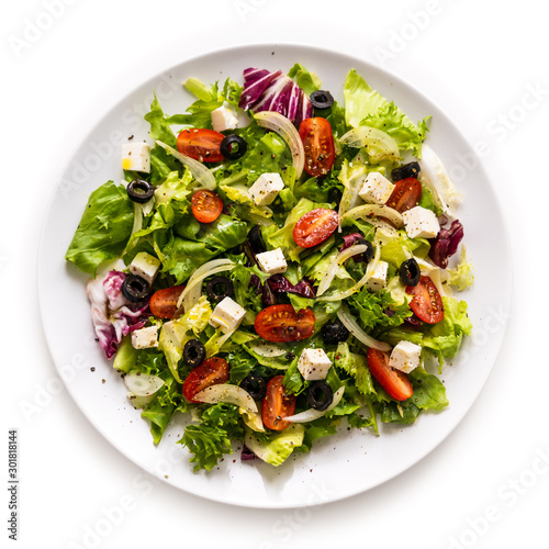Cuadros en Lienzo Fresh greek salad on a plate on white background