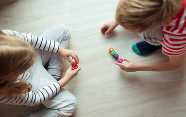 Two clever children study mathematics playing with colorful dices
