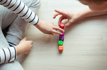 Wall Mural - Two clever children study mathematics playing with dices on the floor