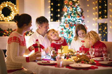 Wall Mural - Family with kids having Christmas dinner at tree