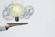 © Who is Danny - Hand holding tablet with light bulb