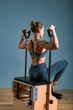 © Georgii - Pilates woman in a Cadillac reformer doing stretching exercises in the gym. Fitness concept, special fitness equipment, healthy lifestyle, plastic. Copy space, sport banner for advertising