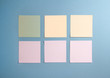 6 blank empty white and pastel colors sticky notes on clean blue background, from top view with copy space