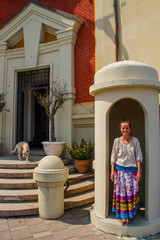 Tirana, Albania - August 20, 2017: street of the capital of Albania, Tirana and a young girl tourist in a bright skirt laughs in a booth near a building in the city center.