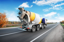 Concrete Mixer Truck Driving Fast On The Countryside Road Against Sky