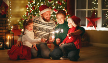 Happy Family Mother, Father And Children Celebrate Christmas And New Year, Light Sparklers.