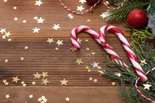 Christmas Background With Candy Canes, Golden Glitter And Decorations On Wooden Board. Copy Space.