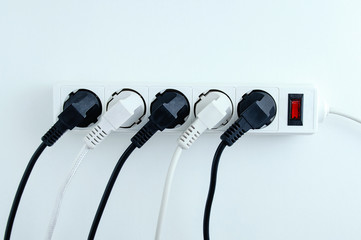 Electric white portable socket with connected devices on a white background.