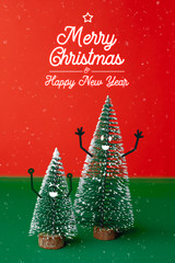 Poster - merry christmas and happy new year type with xmas tree with smile face emotion doodle style decoration on green table with vivid red and snowing background.holiday celebration greeting card