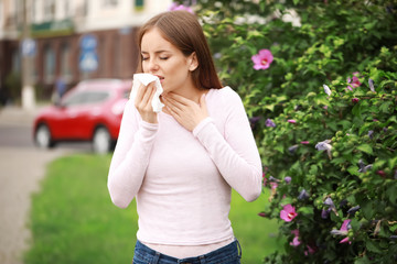 Wall Mural - Young woman suffering from allergy outdoors