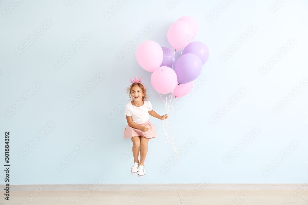 Jumping little girl with balloons on color background - obrazy, fototapety, plakaty 