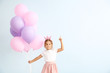 © Pixel-Shot - Little girl with balloons and raised index finger on color background