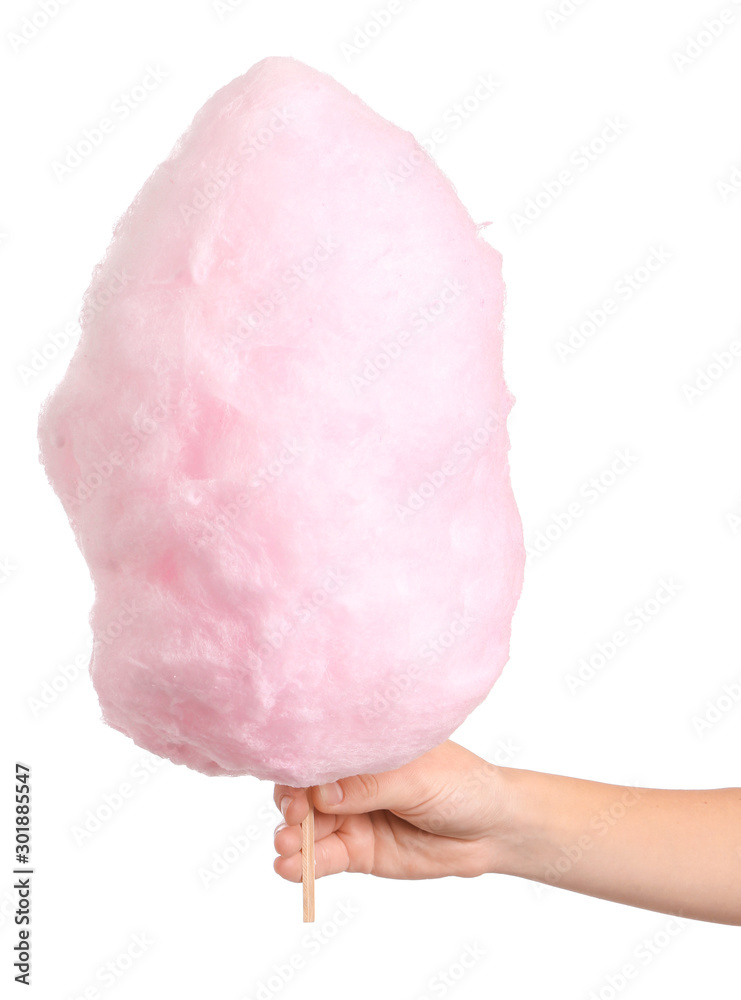 Female hand with tasty cotton candy on white background