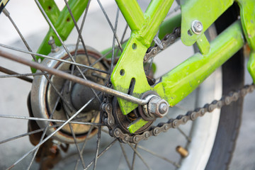 Chains and bolts that attach to the green bicycle wheel