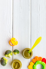 Mashed broccoli for feed babies on white wooden background top view copy space