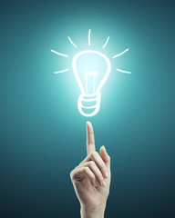 Leinwandbilder - Hand pointing to light bulb