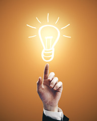 Leinwandbilder - Businessman hand pointing to drawing light bulb