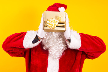 Santa Claus holding Christmas gift with yellow background