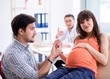 © Elnur - Pregnant woman with her husband visiting the doctor in clinic