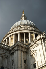 Wall Mural - sunny detail view of the dome of st paul's cathedral under dramatic gray cloud sky in london, uk