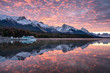 Canadian rockies with commercial dock and colorful altocumulus clouds reflections on Maligne lake