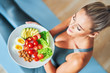 © Kalim - Adult woman eating healthy lunch and sitting on yoga mat