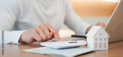 Fotografía close up young man hand press on calculator to check and summary expense of home