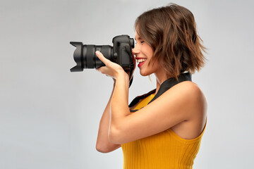 Sticker - people and photography concept - happy woman photographer in mustard yellow top with digital camera over grey background