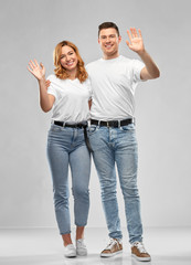 Poster - relationships and people concept - happy couple in white t-shirts waving hands over grey background