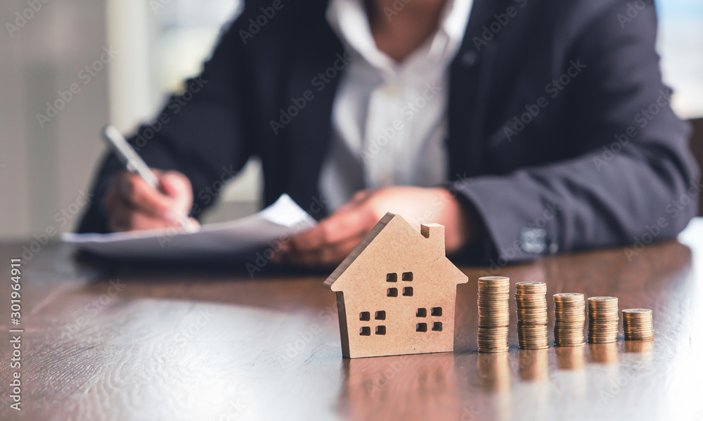 Modeling wooden houses and coins and dollars placed on wooden tables,preparation concept for house model purchase and the fastest growing real estate economy,moving home or renting property via agent - obrazy, fototapety, plakaty 