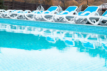 Blue Swimming Pool And Deck Chair Background