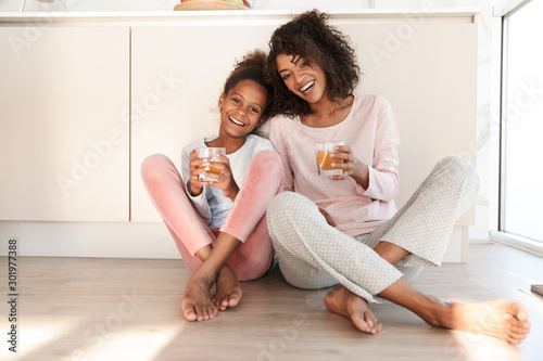 Cuadros en Lienzo Smiling young mother and her little daughter wearing pajamas