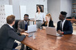 © alfa27 - Young business people gathered in meeting office, everyone dressed in formal suits, using laptop. Business concept