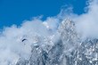 paragliding flies through the clouds over the rocky alps