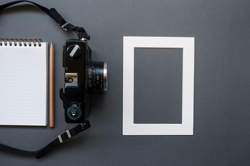 Work office desk with notepad, pencil, photo camera and frame