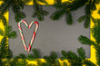 Festliches Weihnachten,herz aus Zuckerstangen auf helldunkelschwarzer Hintergrund mit schöner Textur und Tannenästen, Draufsicht, copy space